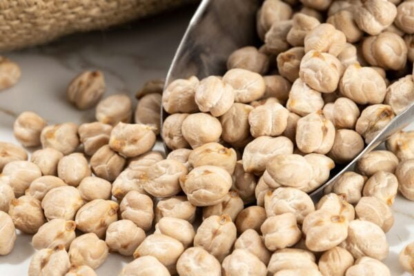 Close up of Chickpeas on scoop on White marble Background
