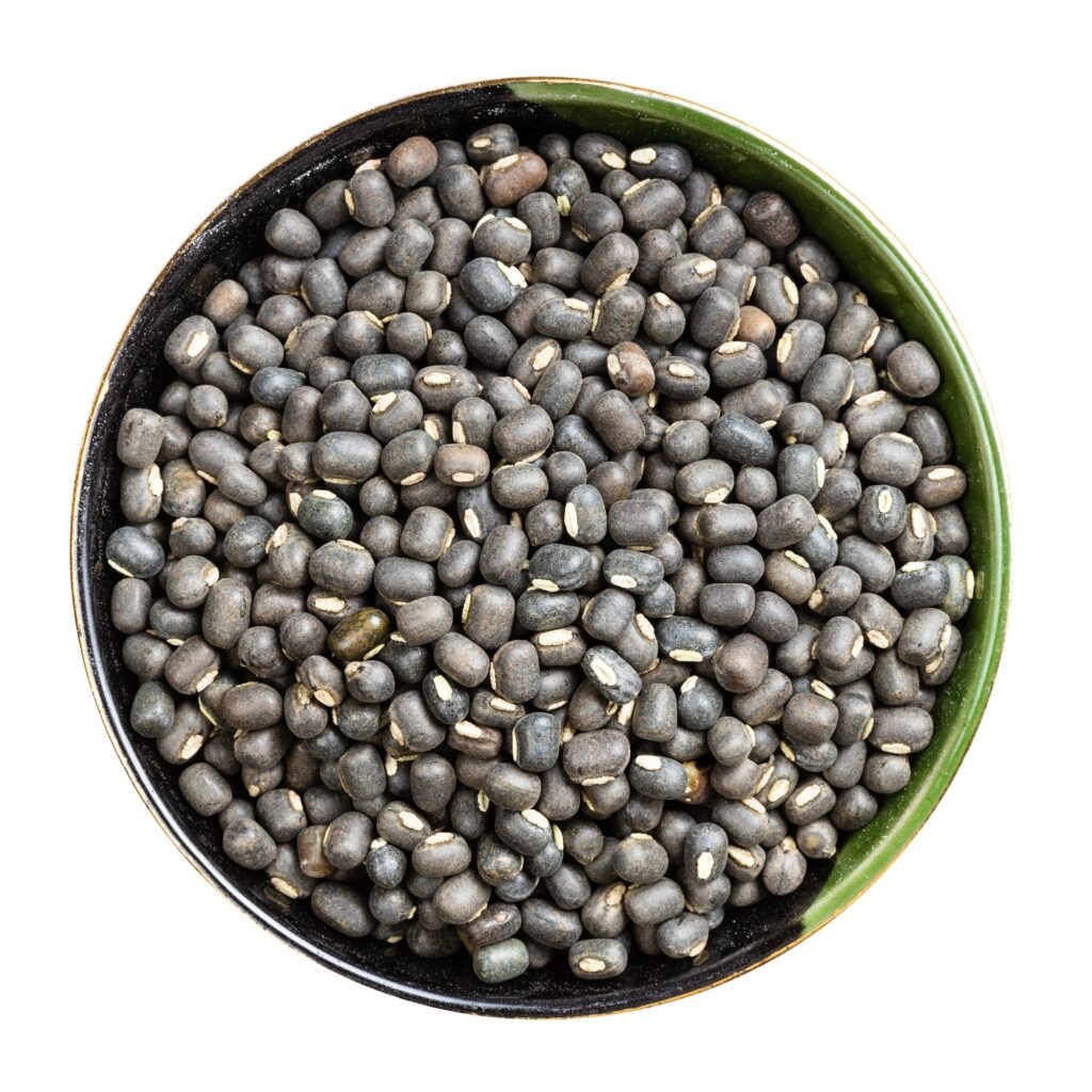 whole black urad beans in round bowl isolated